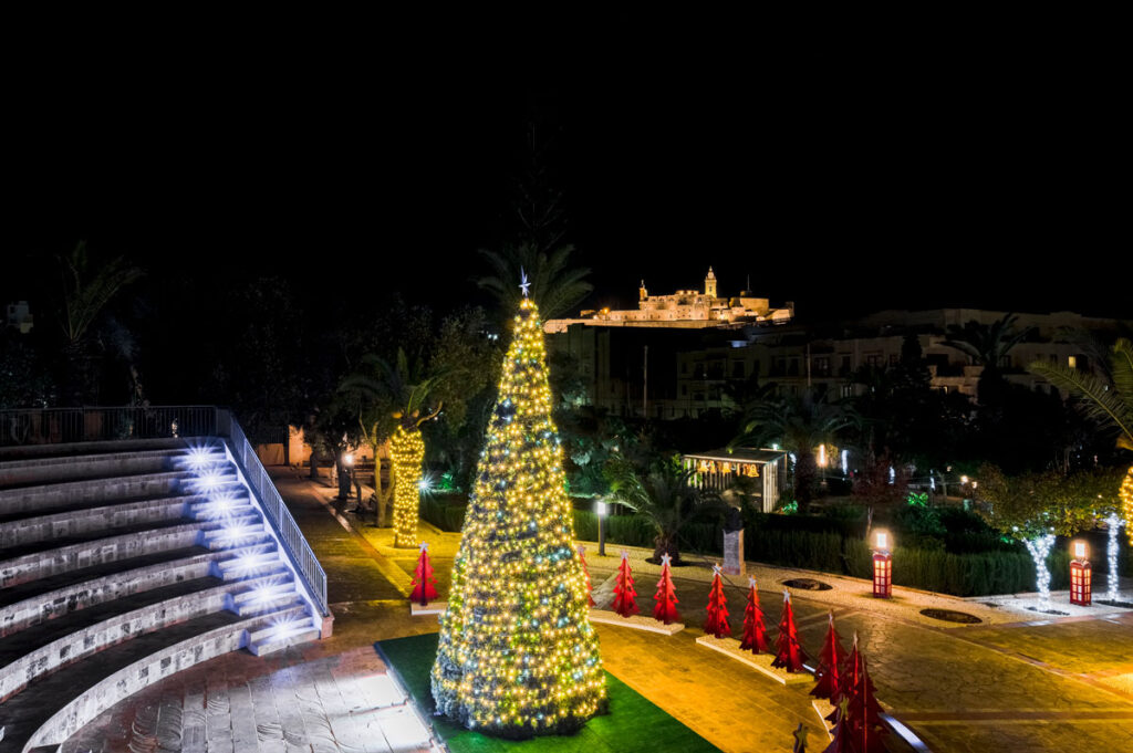 villa rundle christmas tree backdropped by the gozo cittadella