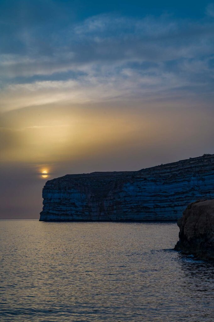 sunset at xlendi bay with very calm sea
