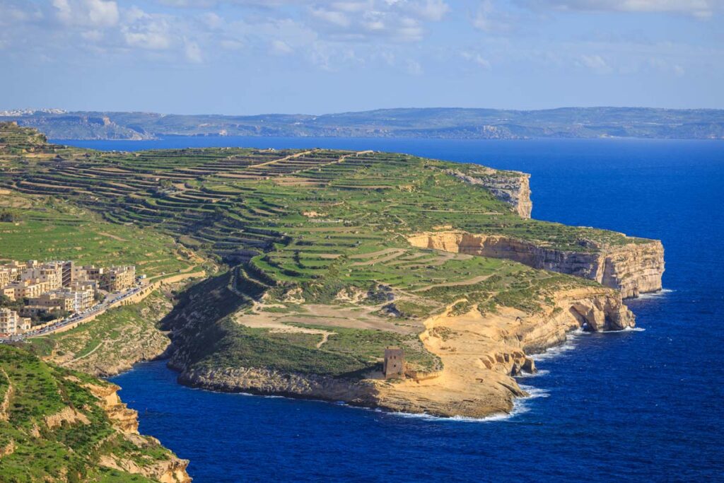 shot of xlendi bay backdropped by the gozo cliffs and mainland malta